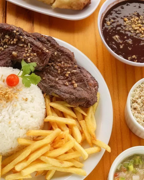 Prato de carne na chapa com alho, arroz, batata frita, feijão e farofa.